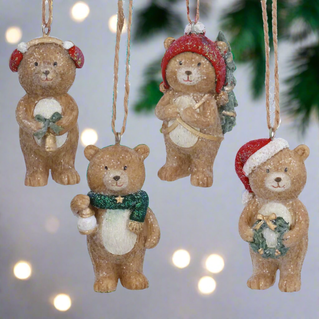 Set of four Christmas-themed bear ornaments on a white background