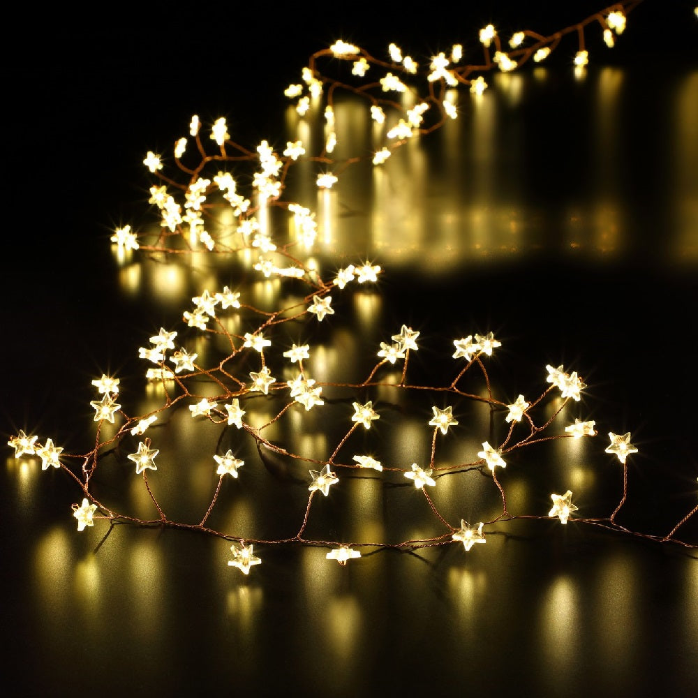 A string of warm white LED Christmas star garland lights placed on a flat surface.