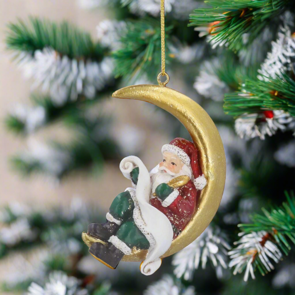 Decorative Christmas ornament featuring Santa Claus on a gold crescent moon.