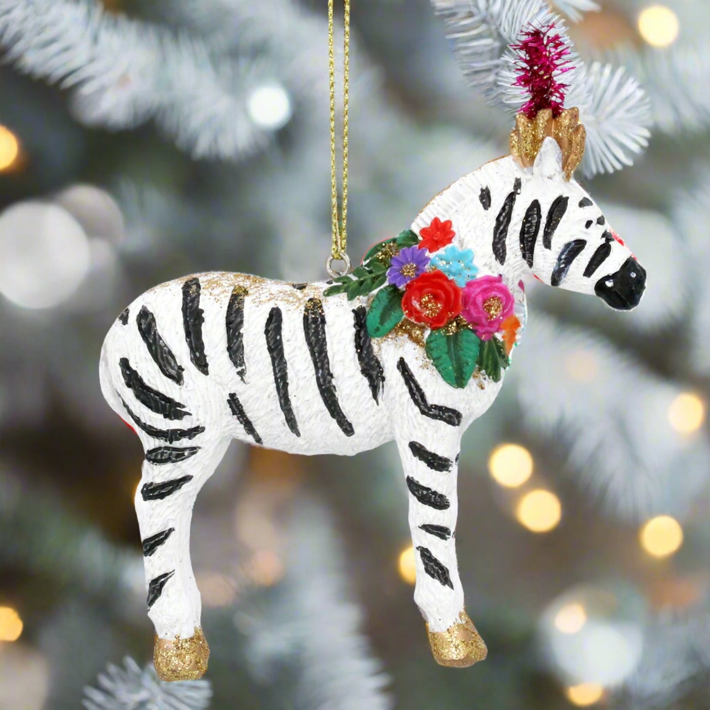 A hanging Christmas tree decoration featuring a carnival zebra with a floral wreath on its neck.
