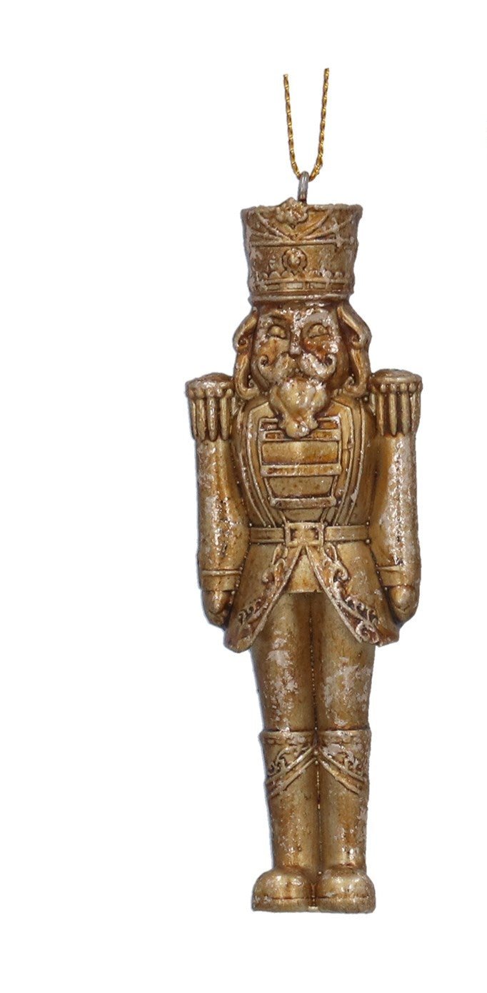 A golden nutcracker hanging from a wire, designed as a Christmas tree decoration, with a traditional, elegant appearance.