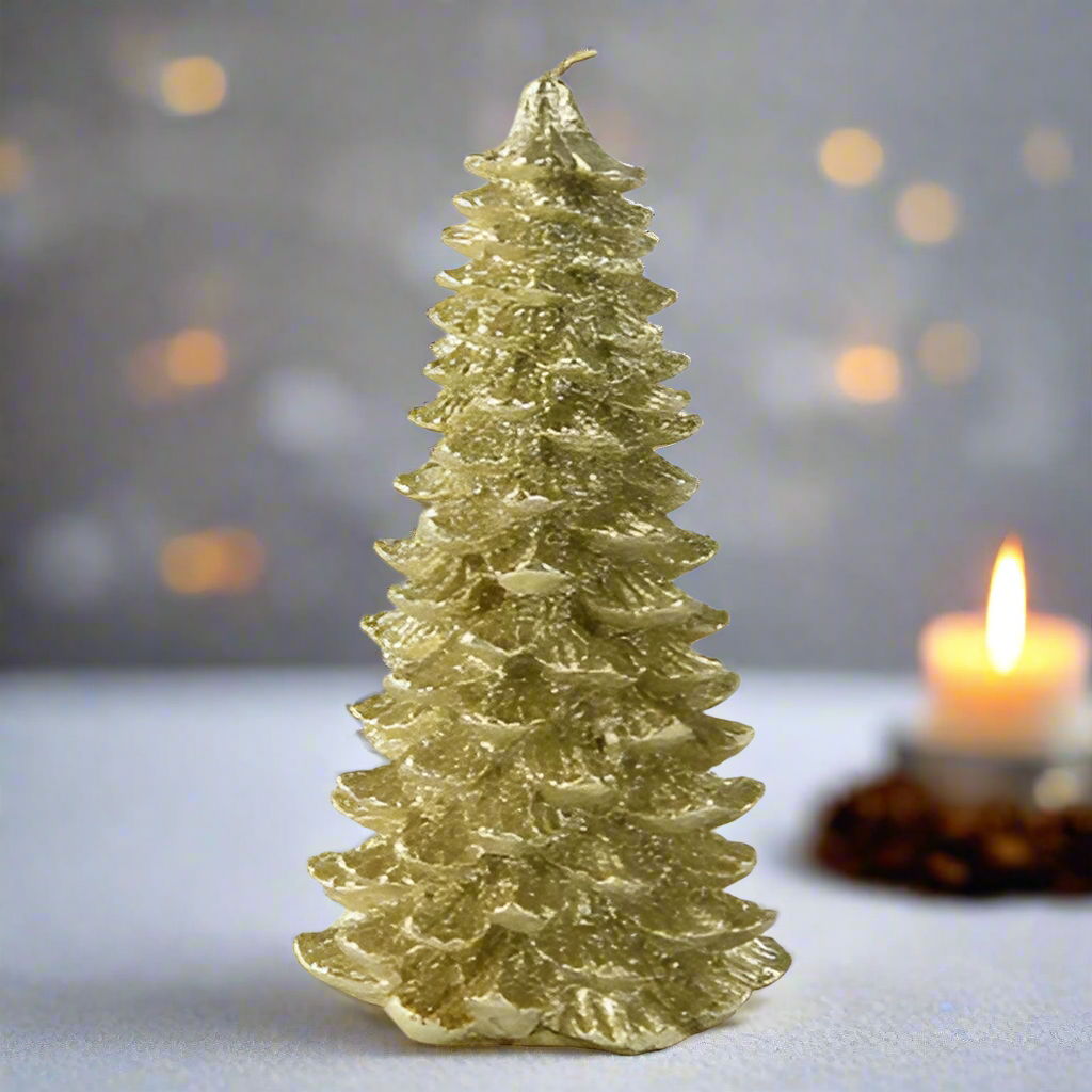 Gold Christmas tree-shaped candle on a blurred background with another candle.