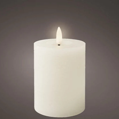 White candle with a lit wick on a dark gray background