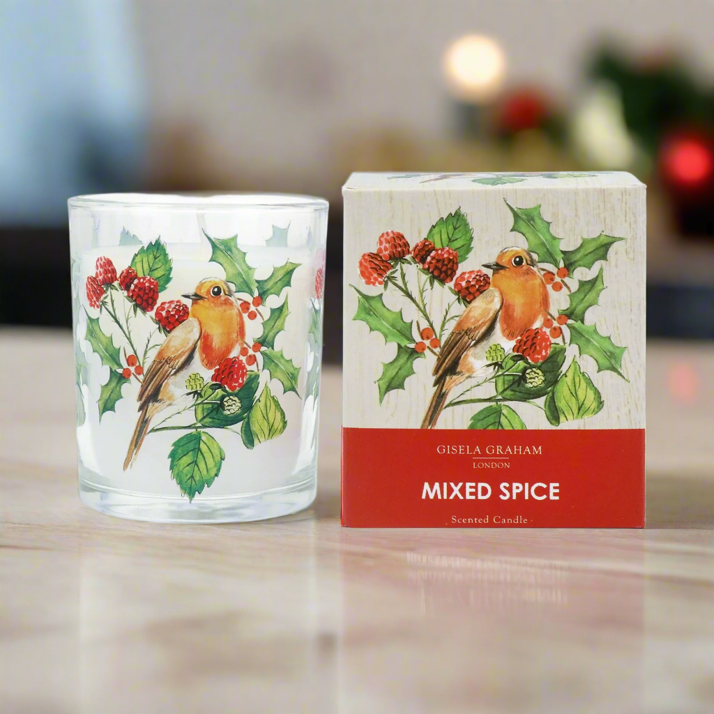 A glass candle with a Christmas design, featuring a robin bird and red berries, next to its packaging box which has 'Robin and Berries' and 'Mixed Spice' written on it.