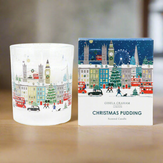 A clear glass scented candle with a Christmas design, featuring an illustration of London landmarks and a Christmas tree, alongside its packaging box with the product title and author's name.