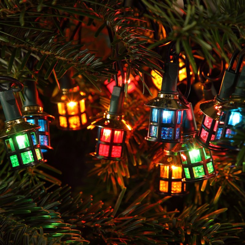 A string of multicolored LED Victorian style lantern lights displayed on a Christmas tree.