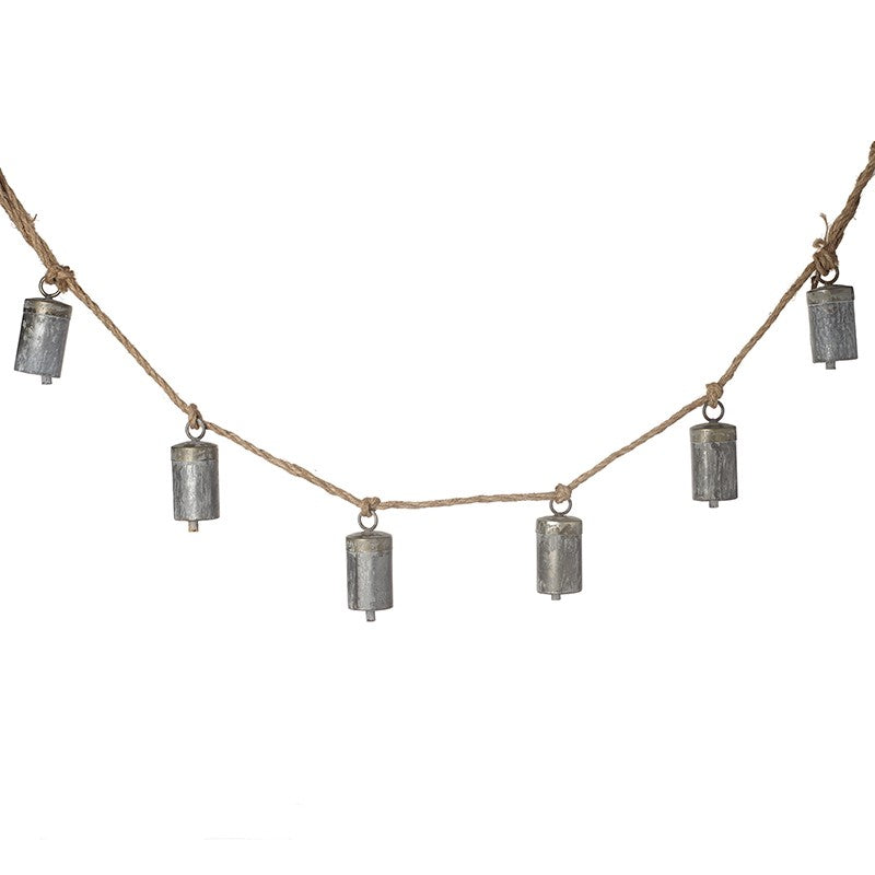 A string of matt silver cow bells with a rustic finish, hung on a jute rope.