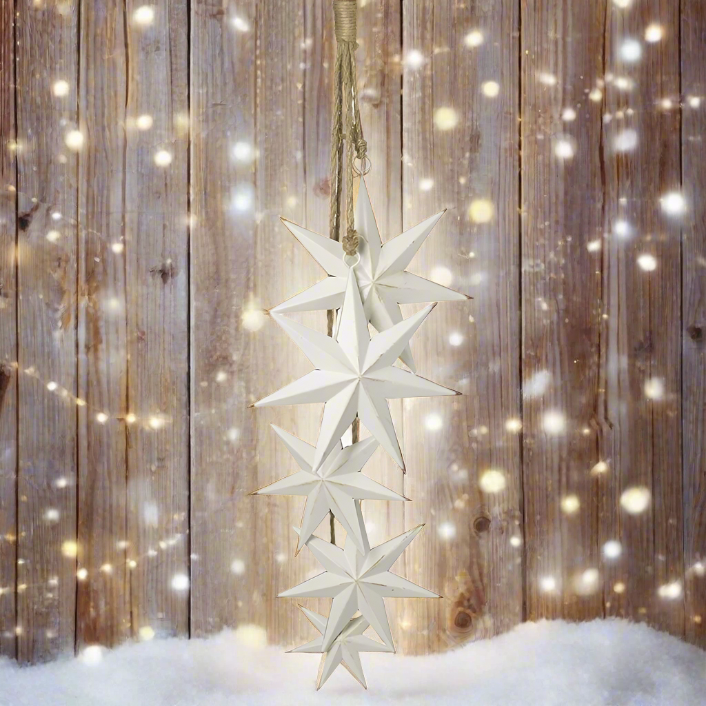 A hanging decoration featuring five white metal stars of different sizes, attached to a jute rope.