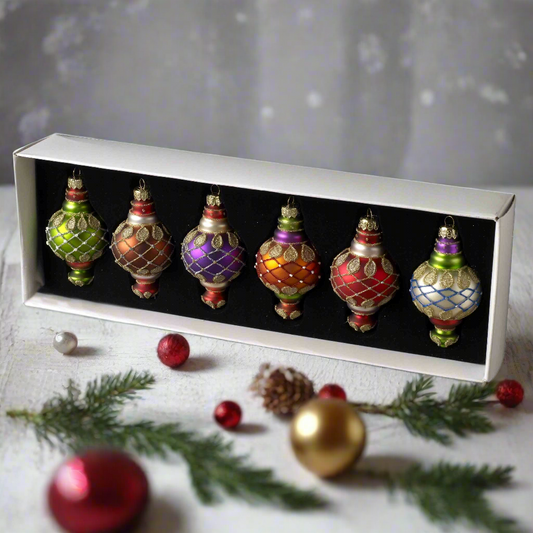 A set of six vintage style glass Christmas tree baubles in a box, featuring various colors and patterns.