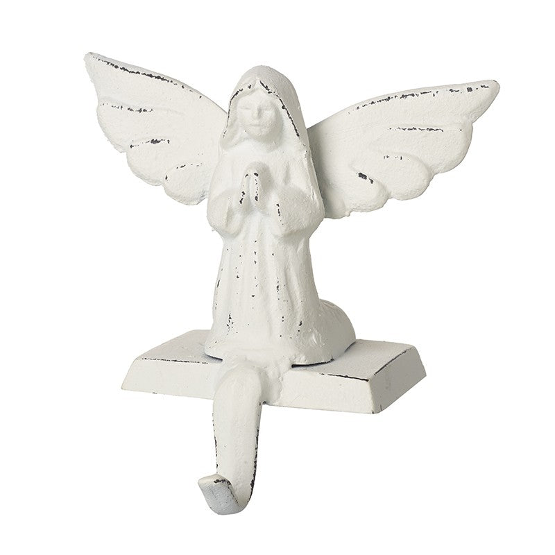 White angel stocking hanger made of cast iron, featuring an angelic figure with outstretched wings in a praying posture, mounted on a base.