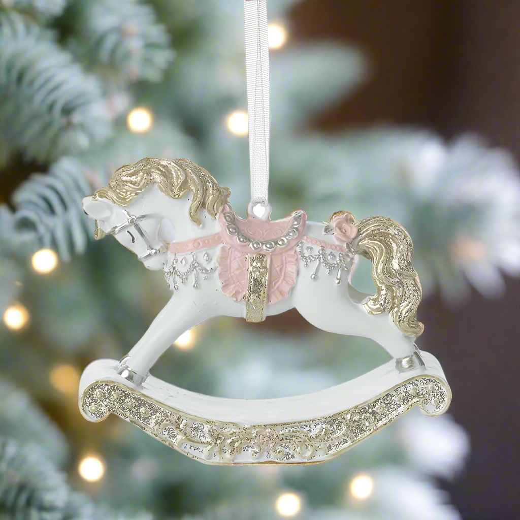 A hanging decoration featuring a gold-colored rocking horse with white and pink details, surrounded by a sparkling ribbon.