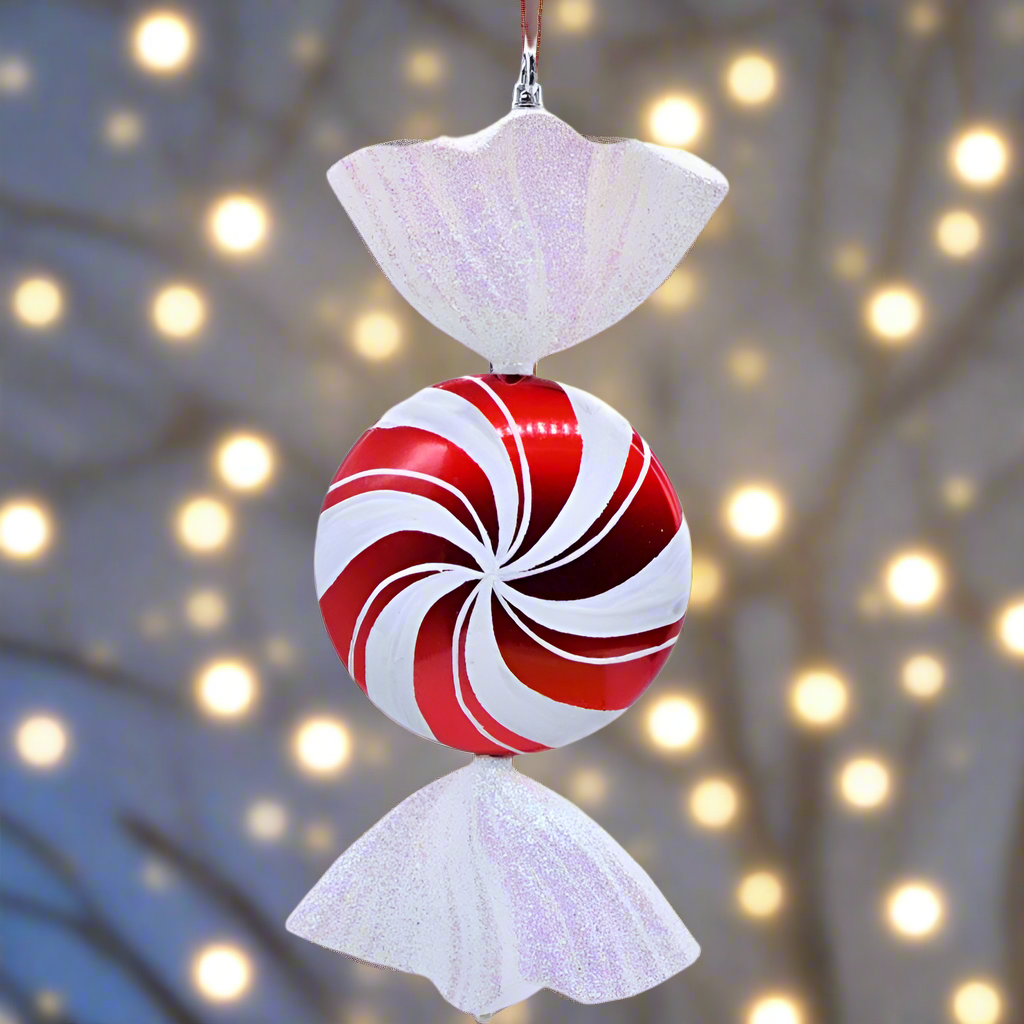 Decorative candy cane ornament with a white top and bottom against a blurred light background