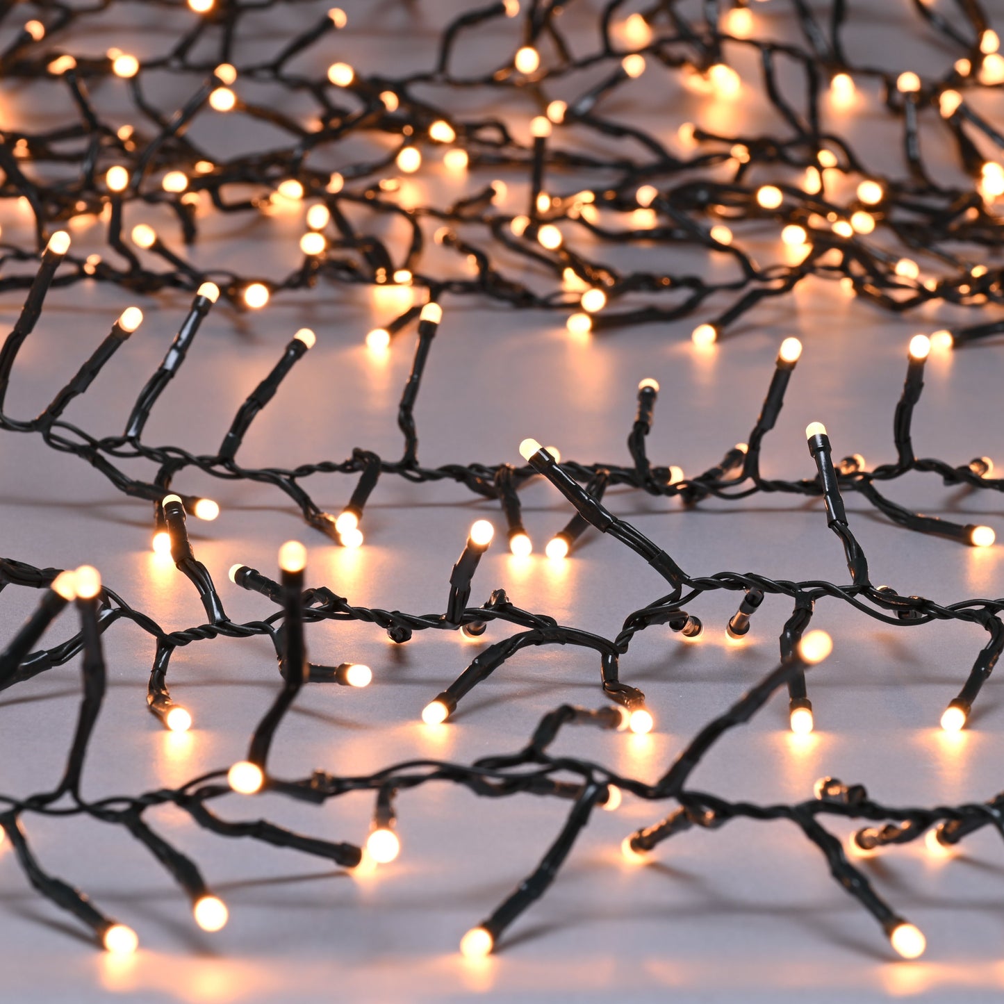 A string of warm white glow worm cluster lights on a white background.