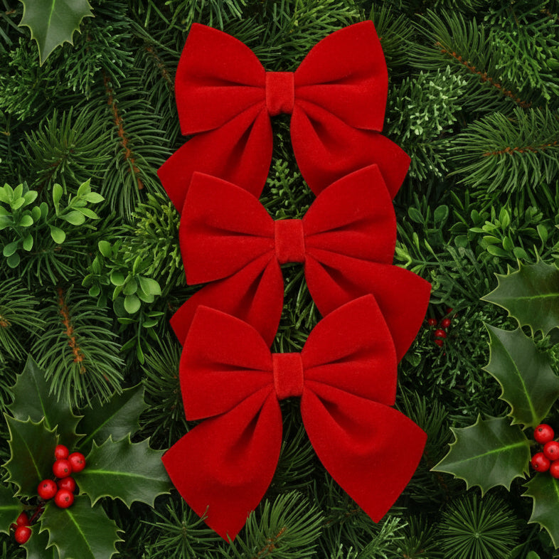 Three red velvet bows on a white card packaging