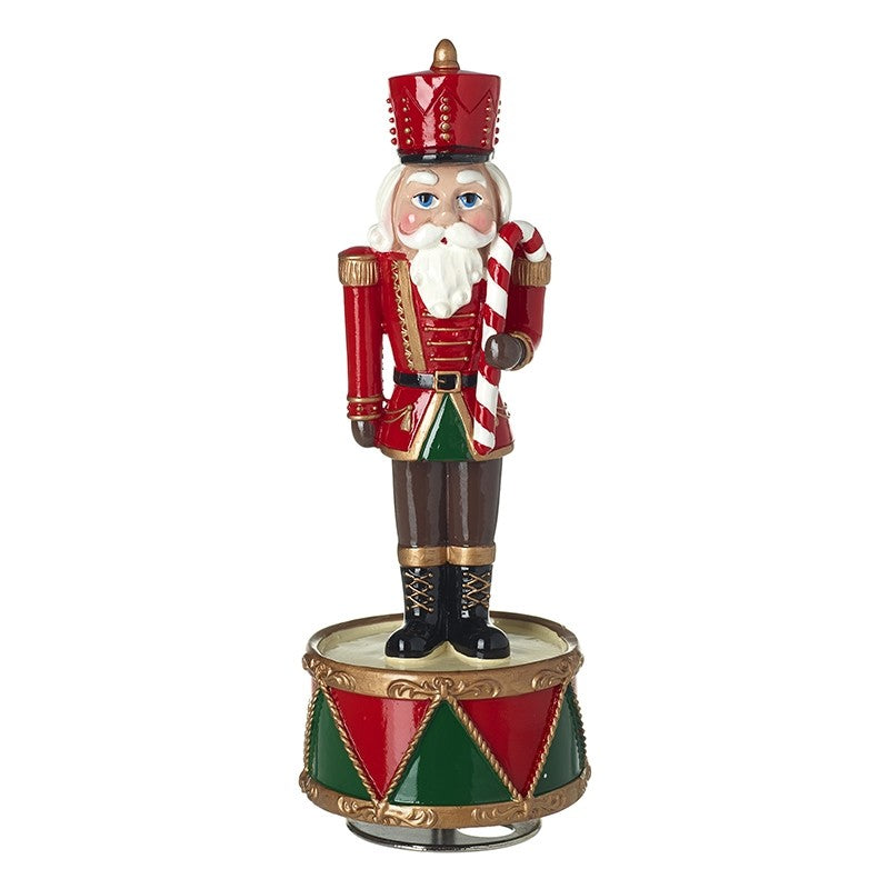 Christmas nutcracker figurine with red hat and striped cane on a white background