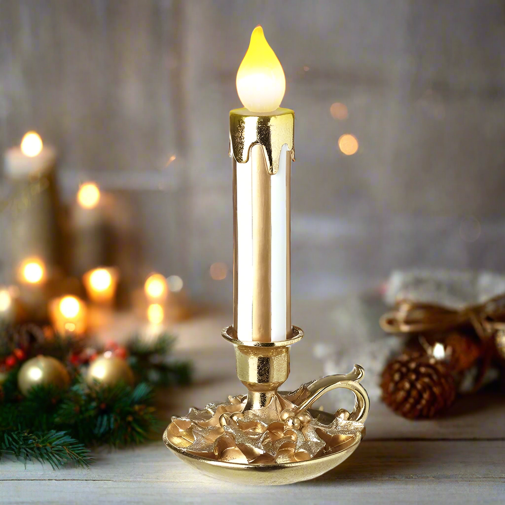 A gold-colored LED lighted candle stick with a flame effect, placed on a decorative base.