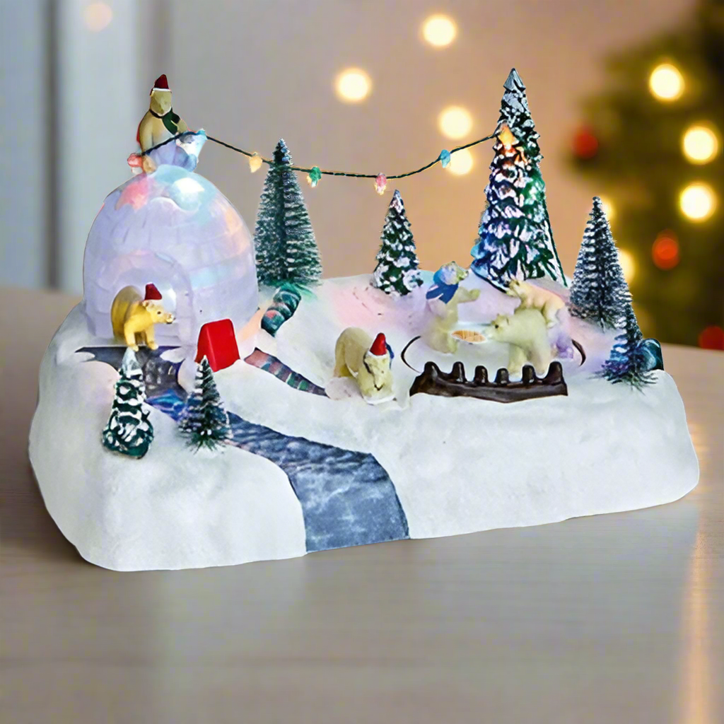 Decorative winter scene with miniature figures and lights on a white surface.