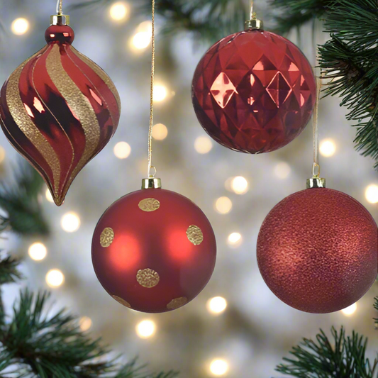 Four red Christmas ornaments with gold accents on a white background