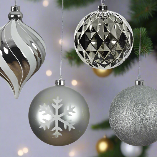 Four silver Christmas ornaments with different designs on a white background