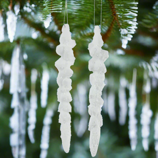 Two white icicle-shaped ornaments on a white background