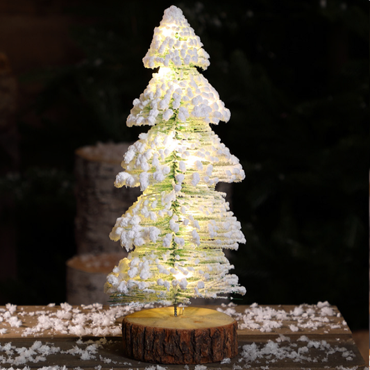 Decorative Christmas tree with lights on a wooden base, set against a dark background.