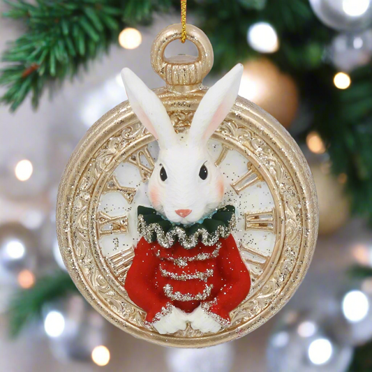Decorative ornament with a rabbit in a red coat inside a gold pocket watch on a white background