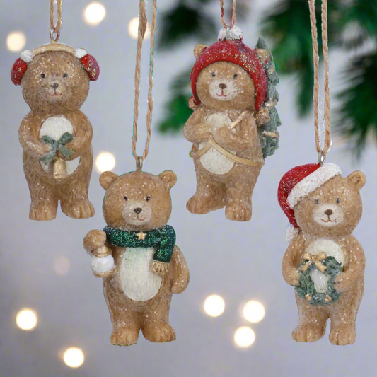 Set of four Christmas-themed bear ornaments on a white background