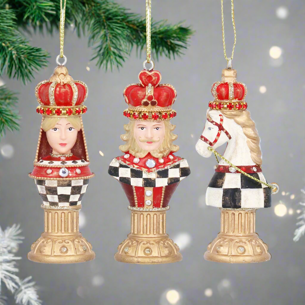 Three decorative chess piece ornaments with crowns on a white background