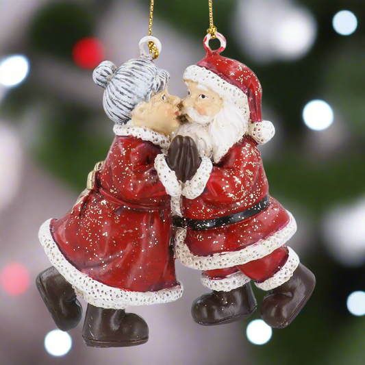 Decorative Christmas ornament of a kissing Santa Claus and Mrs. Claus on a white background