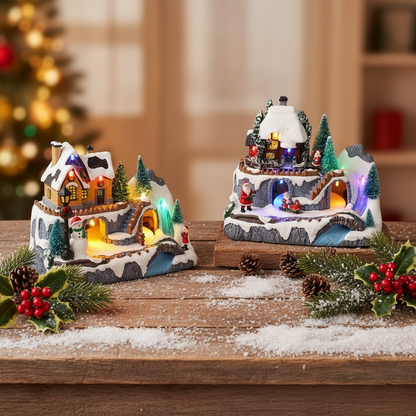 A set of three Christmas village scenes with a mountainous layout, featuring cottages, a sleigh, reindeer, and an alpine train. Each scene is animated with LED lights.