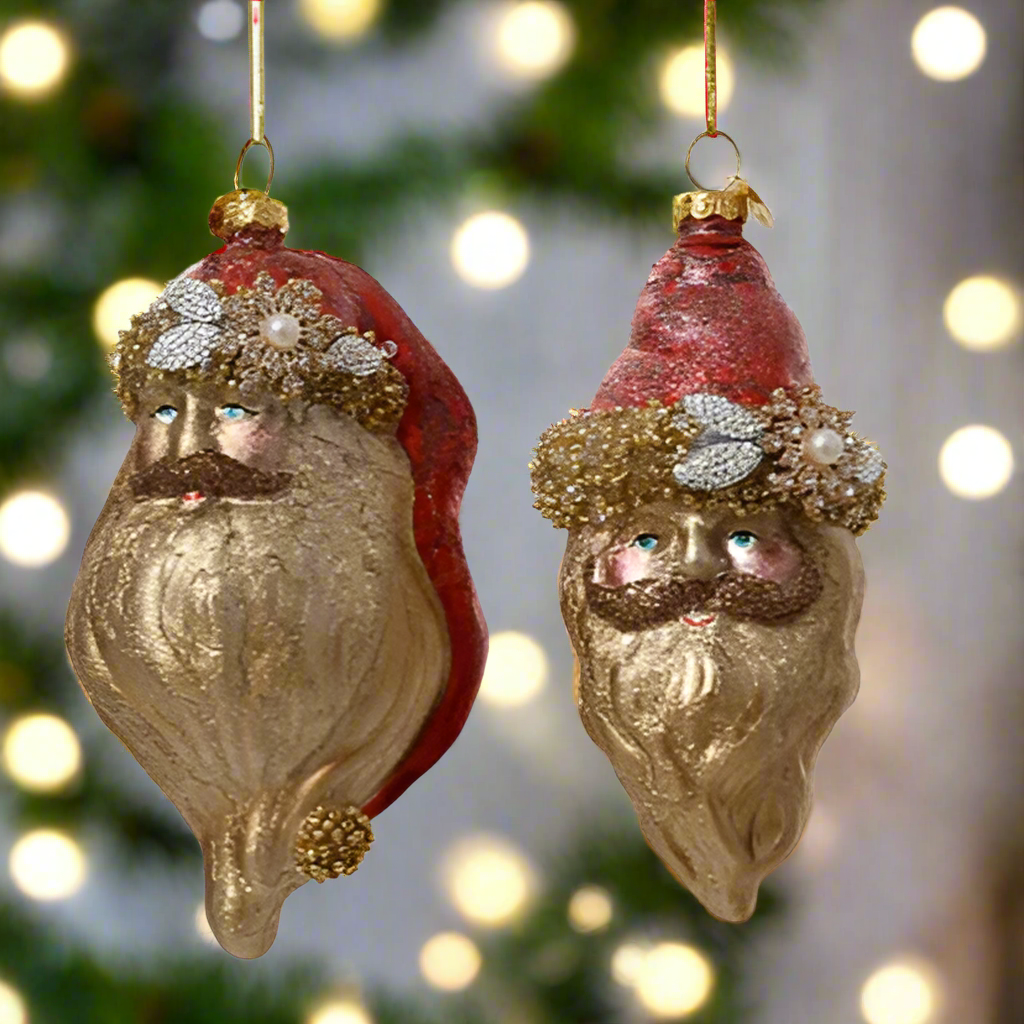 Two decorative Santa Claus ornaments with red hats and gold beards on a white background.