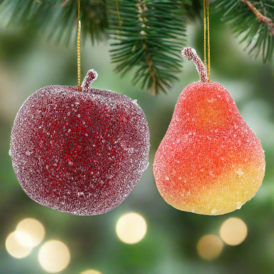 Decorative apple and pear ornaments with a snow-like texture on a white background