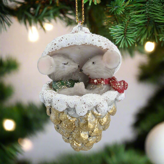 Decorative Christmas ornament with two mice in a snow-covered cone on a white background
