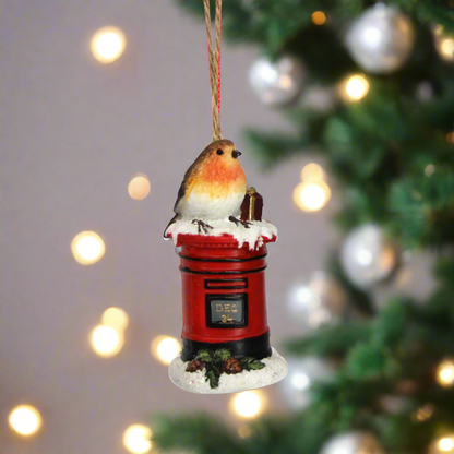 Two decorative Christmas ornaments featuring birds on red telephone boxes against a white background.