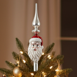 A glass tree topper featuring a Santa Claus design with a red hat and white beard.