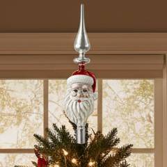 A glass tree topper featuring a Santa Claus design with a red hat and white beard.