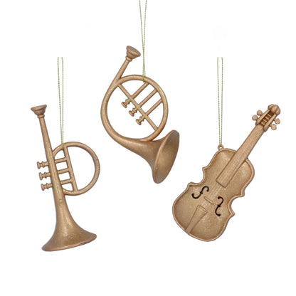 Three wooden ornament shapes of a trumpet, horn, and violin on a white background