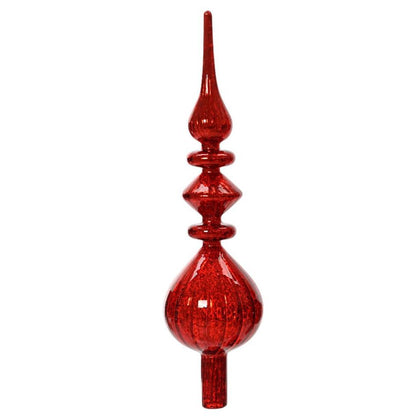 An antique red glass finial in the shape of a Christmas tree topper with a golden tint and distressed appearance.
