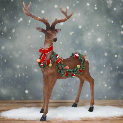 Decorative reindeer figure with a wreath and bow on a white background