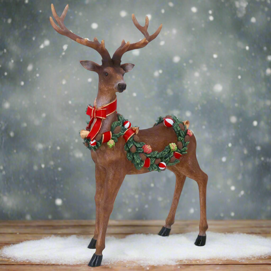 Decorative reindeer figure with a wreath and bow on a white background