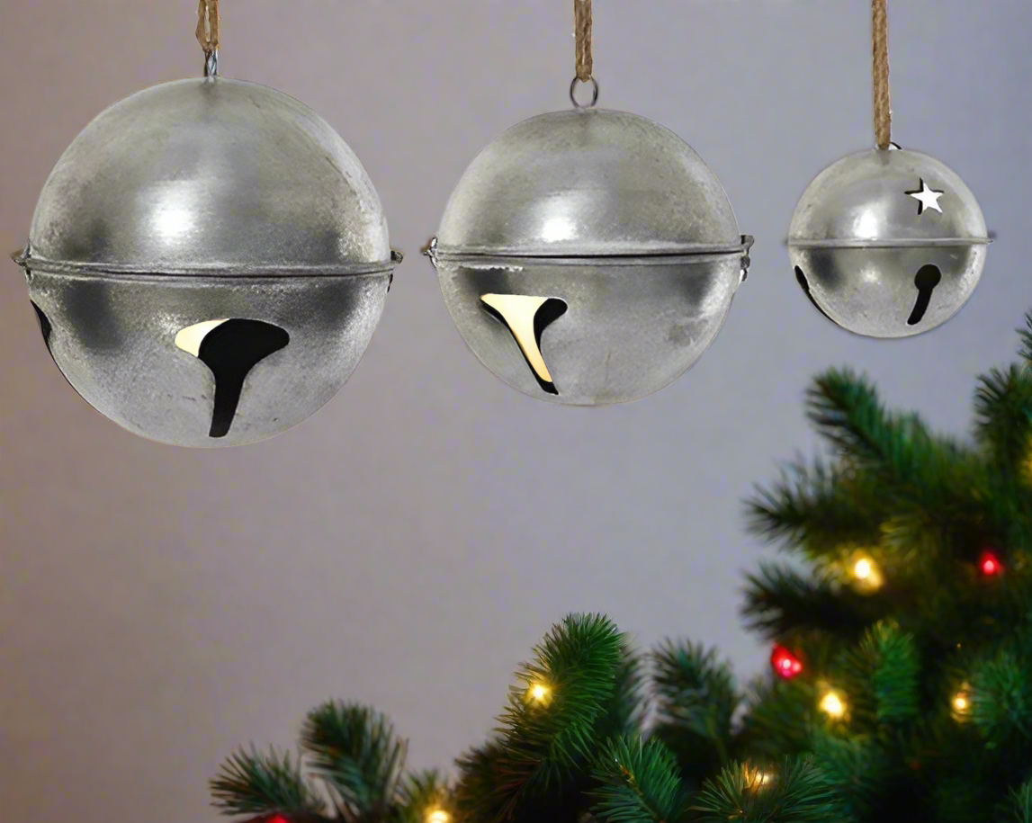 Three metallic bells of different sizes hanging on a white background