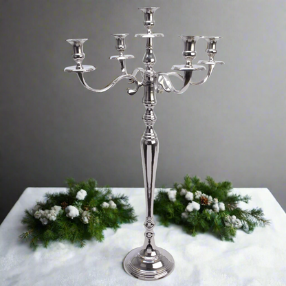A silver candelabra with five candle holders, featuring a classic design and standing on a round base.