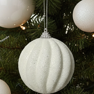 Decorative Christmas tree with white ornaments in a home setting