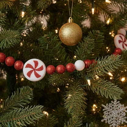 A red and white Christmas garland featuring a candy cane design with white accents and a red spider web decoration.