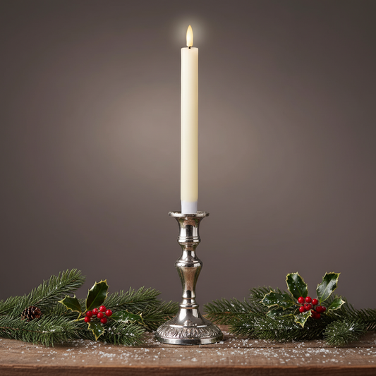 A single white candle with a flat top wick, glowing with a warm white light, set against a dark background.