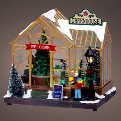 Decorative model of a greenhouse with snow and figures on a brown background
