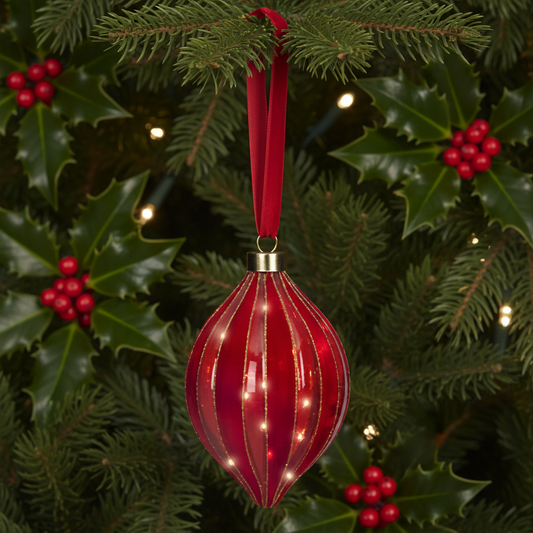 Red Christmas ornament with a gold cap on a gray background