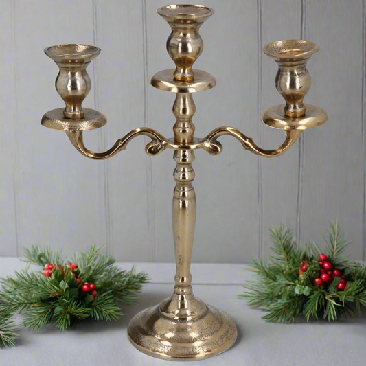 Gold candelabra with three candle holders on a white background