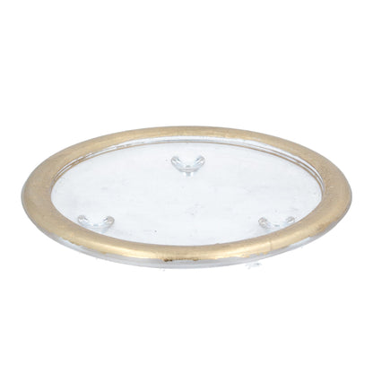 A gold glass candle plate with a reflective surface and decorative detailing around the edge.