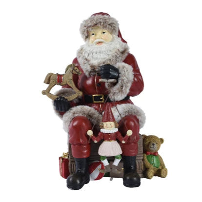 Decorative figure of Santa Claus with a reindeer and gifts on a white background